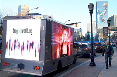 En stor mobil jumbotron-skjerm sirkulerte i sentrum av Atlanta i flere dager og viste Stoffri verden-annonser.