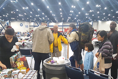 Frivillige Hjælpere ankommer til et nødhjælpscenter i Houston Convention Center og begynder at uddele forsyninger.